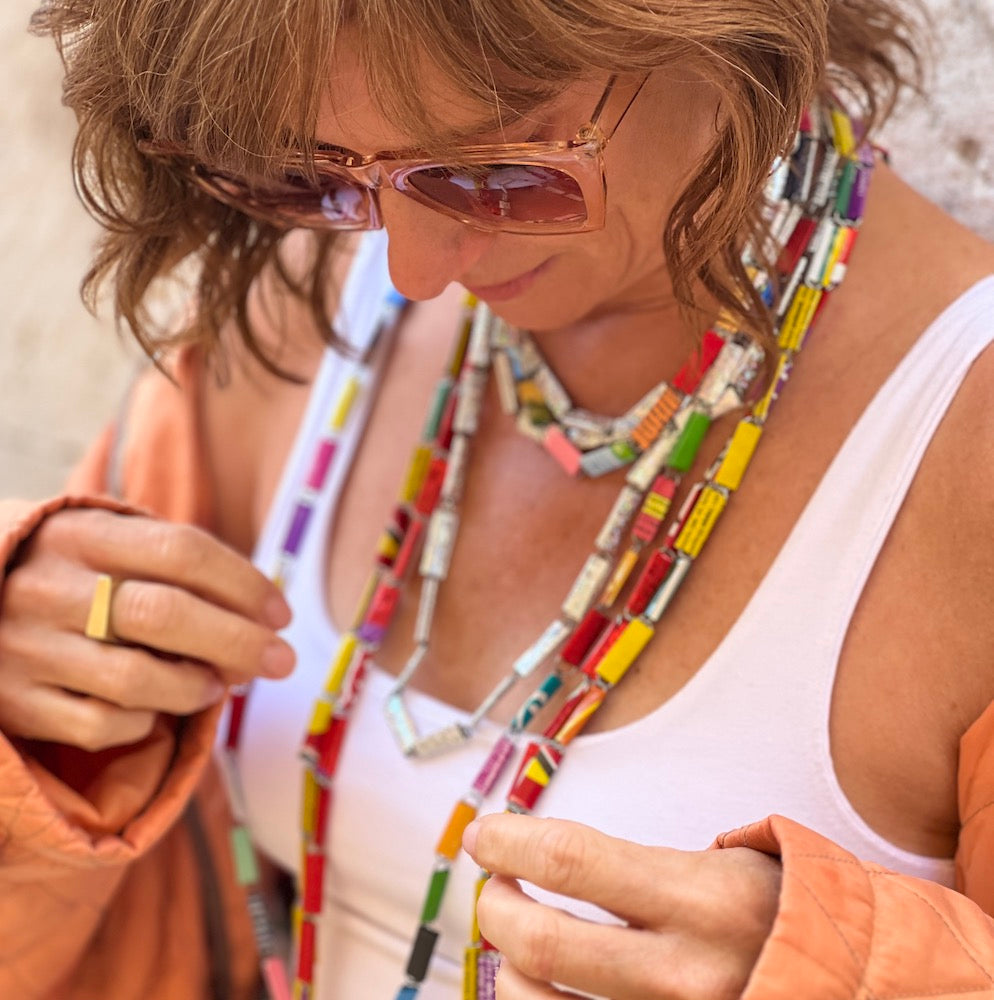 Stacey Shevlin wearing multiple colorful necklaces made of recycled wrappers by Justina Mastina