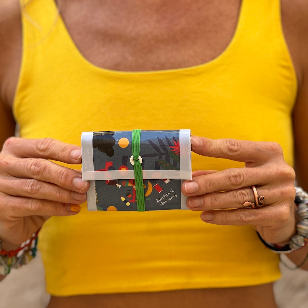 Upcycled carton wallet. blue and grey, held by model