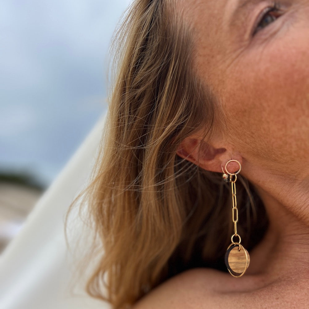 Chain link earrings on model at the sea close up shot