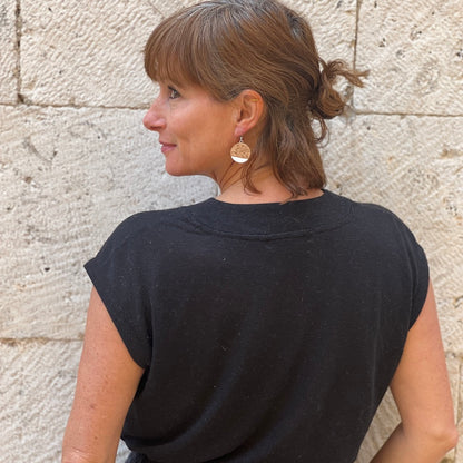 up cycled wine bottle cork earrings with a white tip on woman in black shirt in front of stone wall, Madera Design Studio