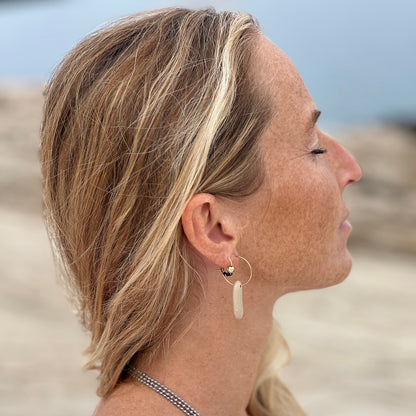 Oval pebble stone earrings on model at beach by Justinart