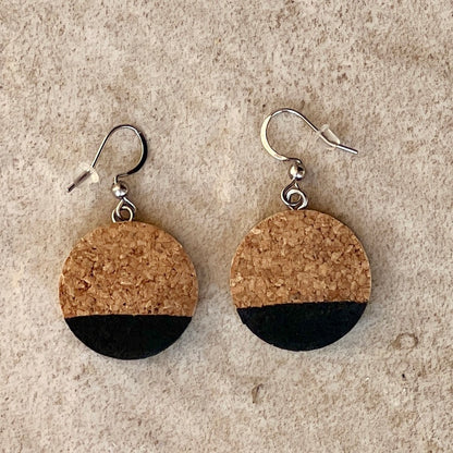 recycled wine bottle cork earrins with black tip on stone background