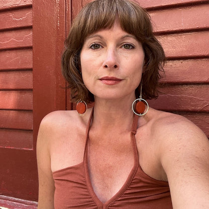 Model in Terracotta hand painted threader earrings in front of a terracotta wall by Madera Design Studio