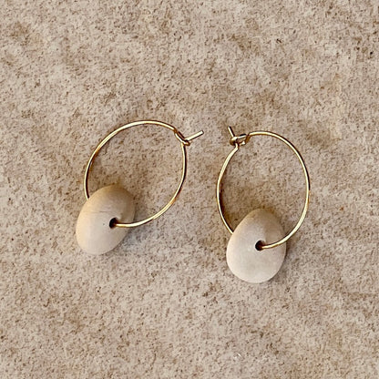 stone pebble circle earrings on stone background