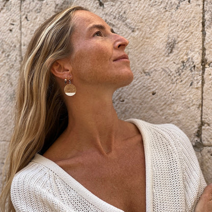 Cork earrings with white tip on model in front of stone wall