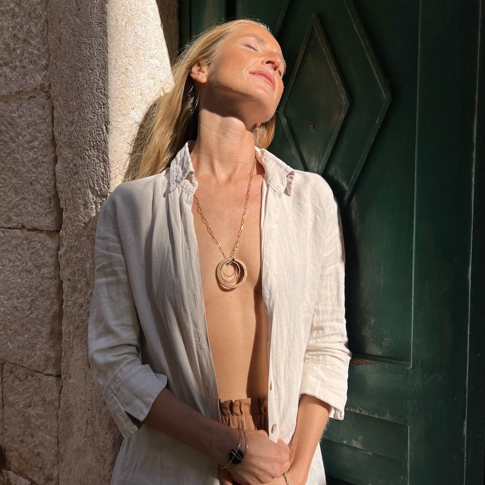 wood and gold circles necklace on blond model in the sun in croatia - madera design studio